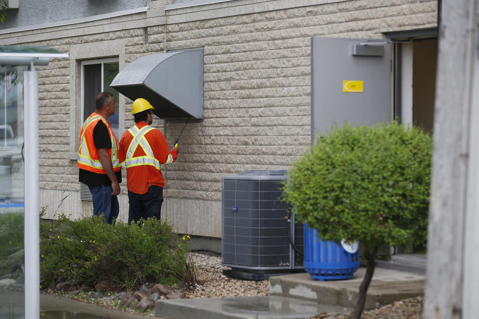 Gas workers check air quality at ventilation vents after emergency personnel were called to a gas leak at a Super 8 hotel in Winnipeg Tuesday, July 9, 2019. Forty six people were taken to emergency hospitals. THE CANADIAN PRESS/John Woods