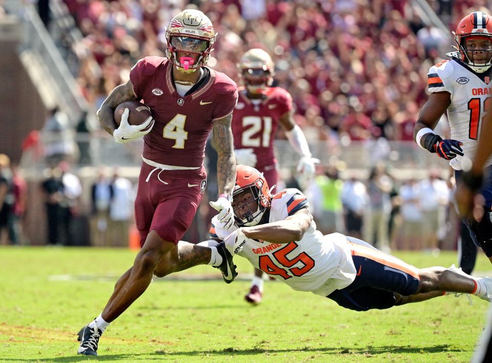 Florida State Seminoles wide receiver Keon Coleman (4) avoids a tackle by Syracuse Orange linebacker Kadin Bailey (45) during the first quarter Oct. 14, 2023, at Doak S. Campbell Stadium in Tallahassee, Florida.