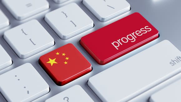 A Chinese flag and the word progress on a keyboard