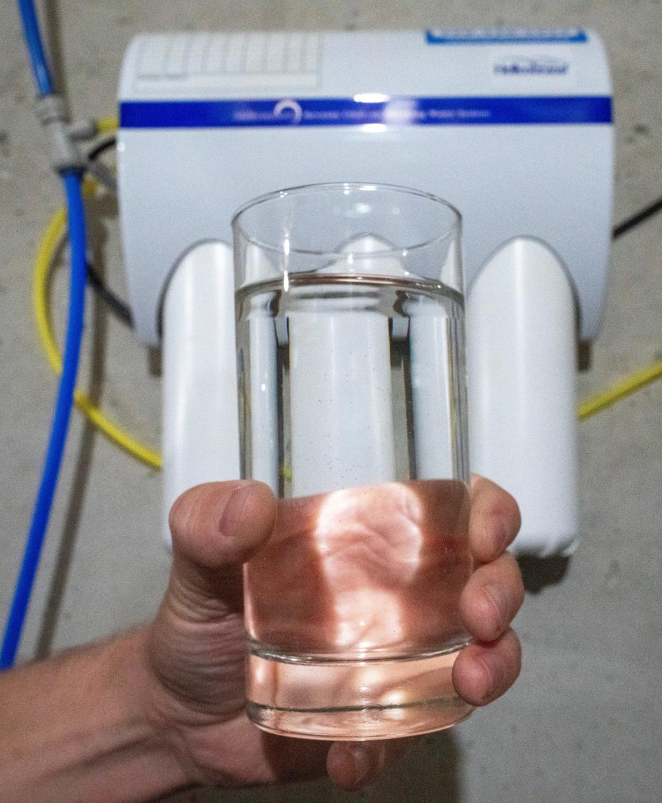 Tyler Frye holds a glass of water that from a reverse osmosis machine (background) Monday, February 5, 2024 in Casco, Wisconsin. The reverse osmosis greatly reduces the amount of nitrates in their water. Newlyweds Tyler and Shannon Frye recently bought their brand new house and discovered their well is contaminated with high levels of nitrates. The contaminated water is a problem for the entire Kewaunee County village which has no municipal water supply.

Mark Hoffman/Milwaukee Journal Sentinel