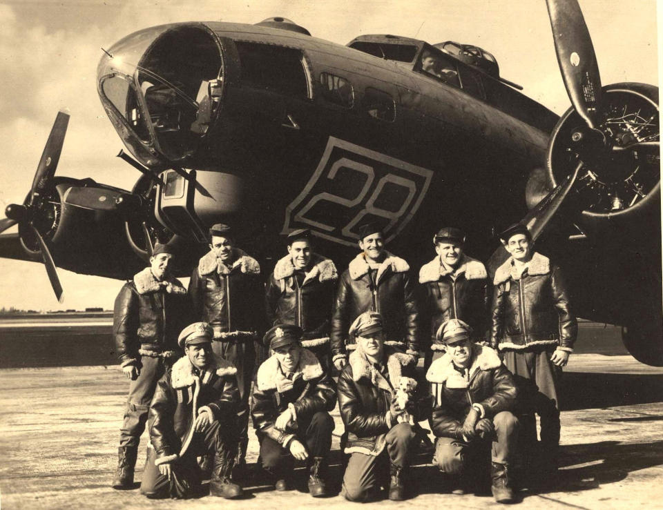 In this image provided by the Kriegshauser family and taken on Oct. 22, 1943 shows the crew posing for a photo in front of a training plane in Geiger Field in Spokane, Washington. They are back row from left: Stf Sgt. Harry Estabrooks, Sgt. Maurice Robbins, Stf Sgt. Robert Mayfield, Sgt. Vito Ambrosio, Sgt. Charles Tuttle and Sgt. George M. Williams. Front row from left: 2nd Lt. Melchor Hernandez, 2nd Lt. John W. Humphrey, 2nd Lt. Lyle Curtis holding the mascot Peanuts and Lt. John G. Kriegshauser. On Friday Feb. 22, 2019 the U.S. and the Royal Air Force are set to honor Lt. John G. Kriegshauser and his crew. (The Kriegshauser family via AP)