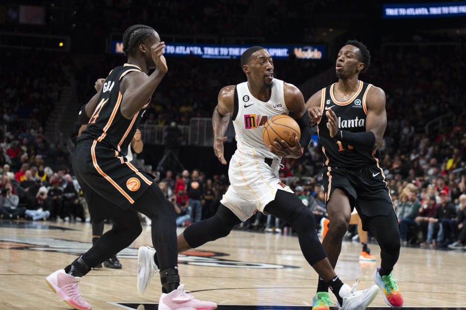 Miami Heat center Bam Adebayo drives between Atlanta Hawks forward AJ Griffin and forward Onyeka Okongwu during the second half of an NBA basketball game, Sunday, Nov. 27, 2022, in Atlanta. (AP Photo/Hakim Wright Sr.)