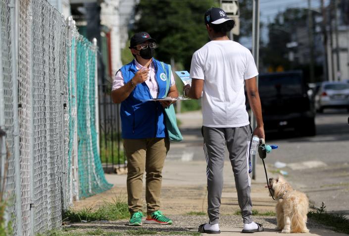 Field canvasser with the New Jersey COVID Community Corp. Leomar Rueda is shown as he speaks to a pedestrian on Woodlawn Ave. in Jersey City.   Monday, August 2, 2021