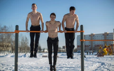 Sober Russia activists Dmitry Petrov, 21, Maxim Solovyov, 17, and Dmitry Nalivaiko, 17, strike a pose at the street workout equipment they petitioned Novgorod authorities to install - Credit: Dmitri Beliakov/For The Telegraph