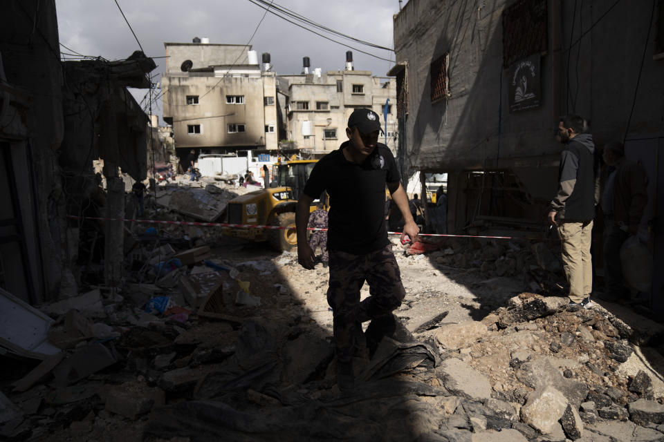 Palestinians security officers secure the parameter of damaged buildings in the West Bank refugee camp of Nur Shams, Tulkarem, Sunday, April 21, 2024. The Palestinian Red Crescent rescue service meanwhile said it has recovered more than a dozen of bodies from an Israeli raid in the Nur Shams urban refugee camp in the West Bank that began late Thursday. Those killed include three militants from the Islamic Jihad group and a 15-year-old boy. (AP Photo/Nasser Nasser)