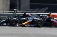 Mercedes driver Lewis Hamilton of Britain, left, and Red Bull driver Max Verstappen of the Netherlands take a curve side-by-side at the start of the British Formula One Grand Prix, at the Silverstone circuit, in Silverstone, England, Sunday, July 18, 2021. (AP Photo/Jon Super)