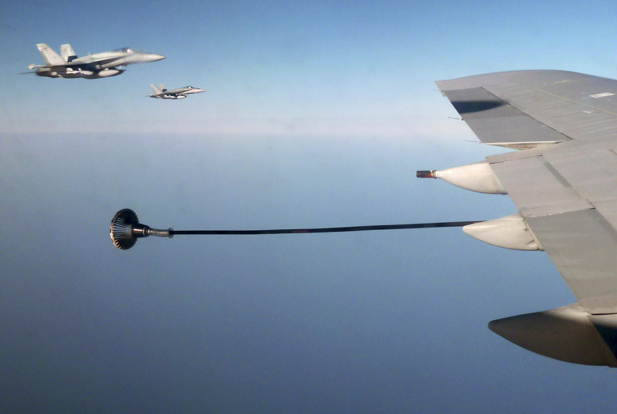 Canadian F-18 war planes (L) wait to refuel from a British VC-10 tanker aircraft over the Mediterranean Sea off Libya July 10, 2011.  REUTERS/David Brunnstrom/File Photo 