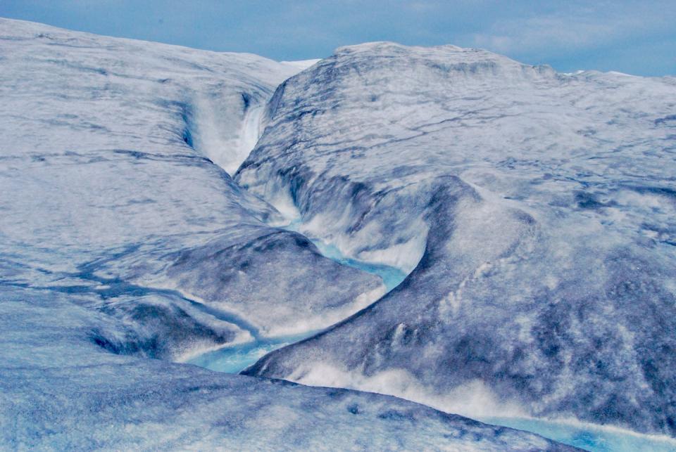 At midnight in July, meltwater flows onto the Greenland ice sheet through a meandering channel.  Paul Bierman