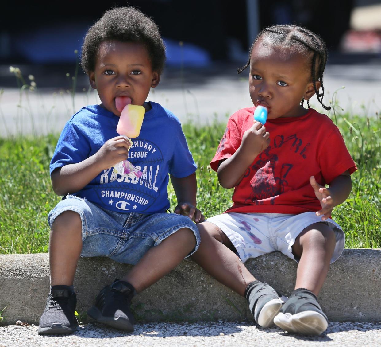 Braxton Vinson, 3, and his brother Noah, 2, enjoy their Popsicles at the Juneteenth Vax and Vote Blitz at the Akron Urban League in Akron on Friday.