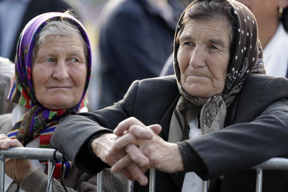 Women wait to see Pope Francis prior to a meeting with young people and families, in Iasi, Romania, Saturday, June 1, 2019. Francis began a three-day pilgrimage to Romania on Friday that in many ways is completing the 1999 trip by St. John Paul II that marked the first-ever papal visit to a majority Orthodox country. (AP Photo/Andrew Medichini)