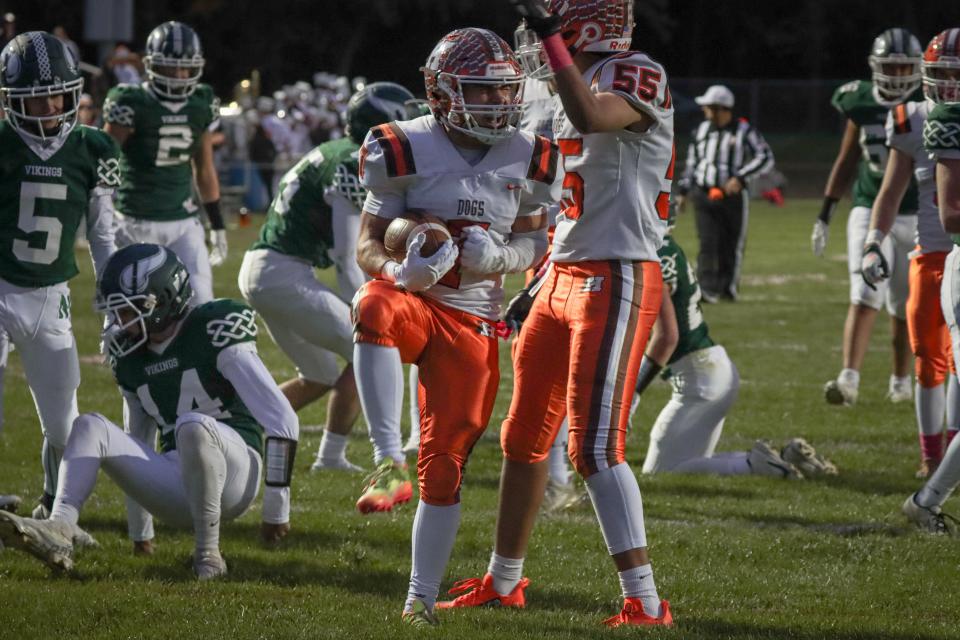 Heath sophomore Connor Corbett celebrates a touchdown with junior Noah Sprague (55) against Northridge on Friday, Oct. 7, 2022. The visiting Bulldogs beat the Vikings 54-0.