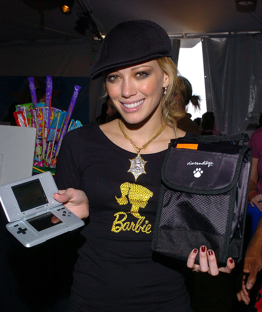Hilary in a Barbie shirt and holding a Nintendo DS console with a "Nintendogs" bag