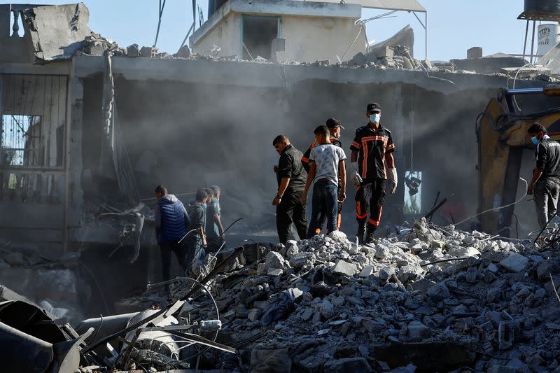 Palestinos buscan víctimas bajo los escombros tras los ataques israelíes en medio del actual conflicto entre Israel y el grupo islamista palestino Hamás, en Jan Yunis, en el sur de la Franja de Gaza