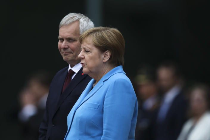 German Chancellor Angela Merkel, right, and Prime Minister of Finland Antti Rinne listen to the national anthems at the chancellery in Berlin, Germany, Wednesday, July 10, 2019. Merkel's body shook visibly as she stood alongside the Finnish prime minister and listen to the national anthems during the welcoming ceremony at the chancellery. (AP Photo/Markus Schreiber)