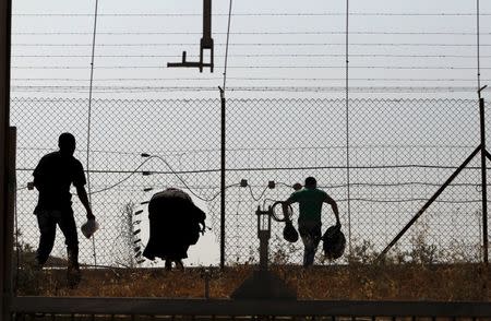 Palestinian labourers from the West Bank illegally cross Israel's controversial barrier in the southern West Bank in this June 22, 2013 file photo. REUTERS/Ammar Awad/Files