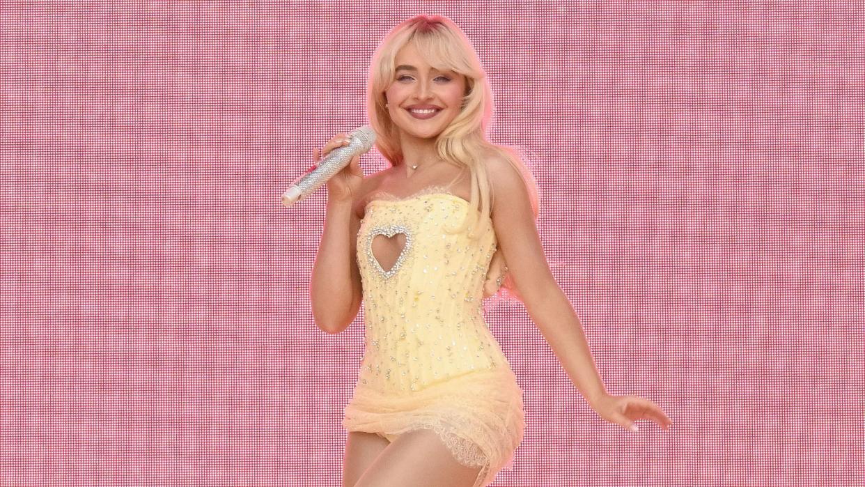 Sabrina Carpenter performing on stage, wearing a yellow dress in front of a pink background