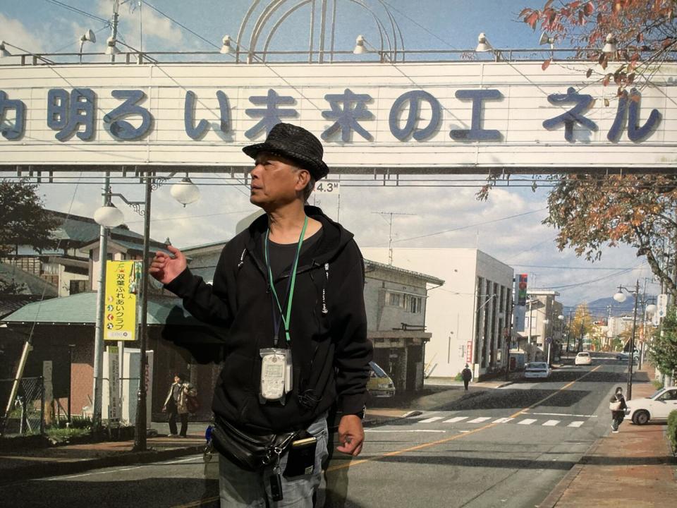 Man wearing a lanyard with a banner behind him