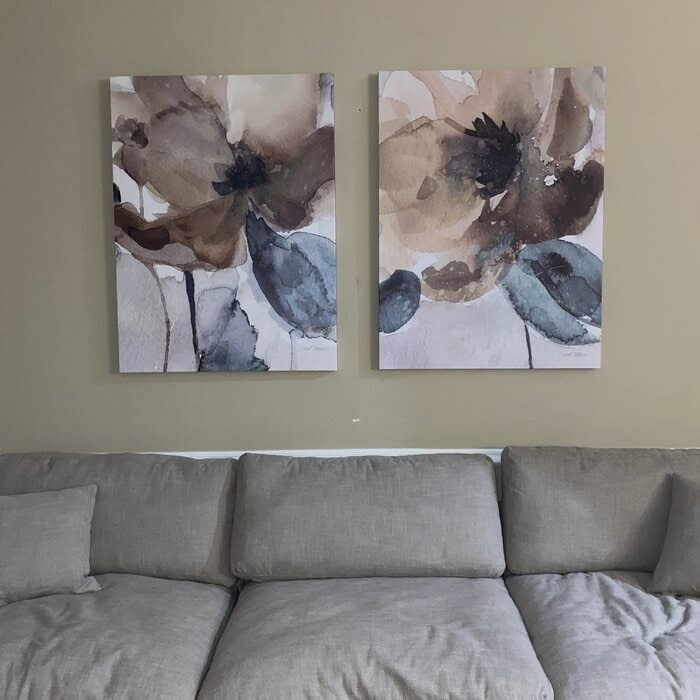 A reviewer's photo of two of the poppy canvases hanging above her couch