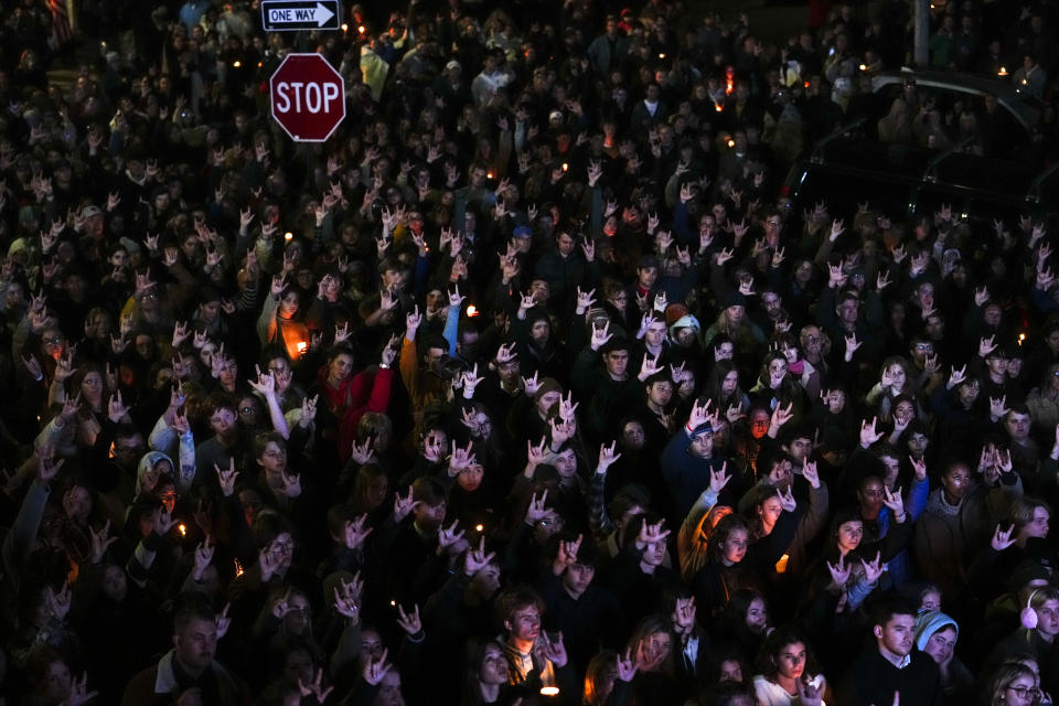 People sign "I love you" while gathered at a vigil for the victims of Wednesday's mass shootings, Sunday, Oct. 29, 2023, outside the Basilica of Saints Peter and Paul in Lewiston, Maine. (AP Photo/Matt Rourke)