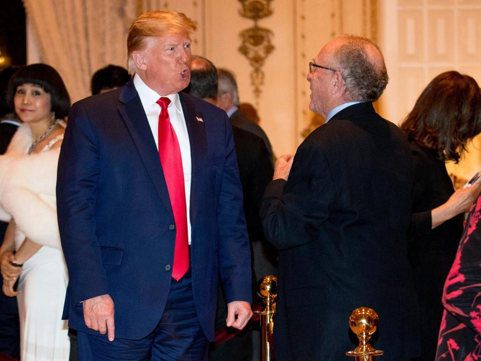 FILE - in this Dec. 24, 2019, file photo, President Donald Trump speaks to attorney Alan Dershowitz, right, as he arrives for Christmas Eve dinner at Mar-a-lago in Palm Beach, Fla. Retired law professor Alan Dershowitz says he hasn't changed at all and has a long history of representing people whose views he doesn't necessarily agree with. Dershowitz is part of President Donald Trump's defense team at the Senate impeachment trial. (AP Photo/Andrew Harnik, File)