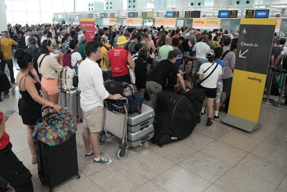 Passengers wait to check in at Josep Tarradellas Barcelona-El Prat Airport, in Barcelona