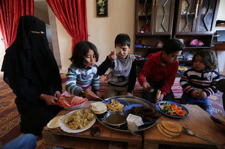 Palestinian boy Mohammad An-Najjar, 12, who was wounded in his eye during a protest at the Israel-Gaza border fence, eats lunch with his brothers and mother Lamia Abu Harb inside their family house, in Khan Younis, in the southern Gaza Strip, January 21, 2019. REUTERS/Ibraheem Abu Mustafa