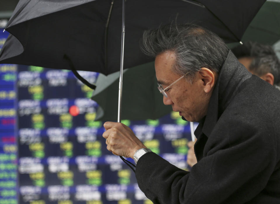 People walk by an electronic stock board of a securities firm in Tokyo, Tuesday, Feb. 4, 2014. Weakness in U.S. and Chinese manufacturing sent Asian stock markets sharply lower Tuesday. (AP Photo/Koji Sasahara)