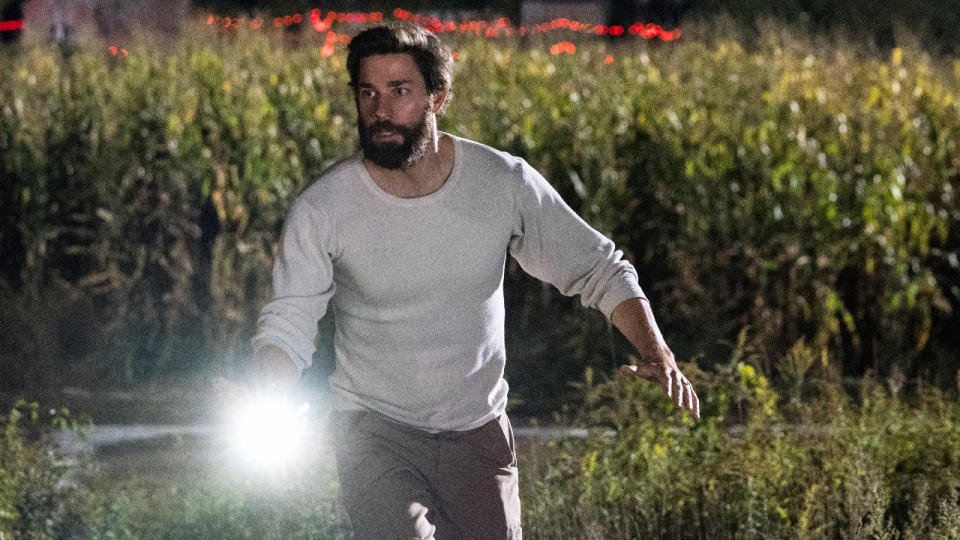 John Krasinski running with a flashlight in hand in A Quiet Place.