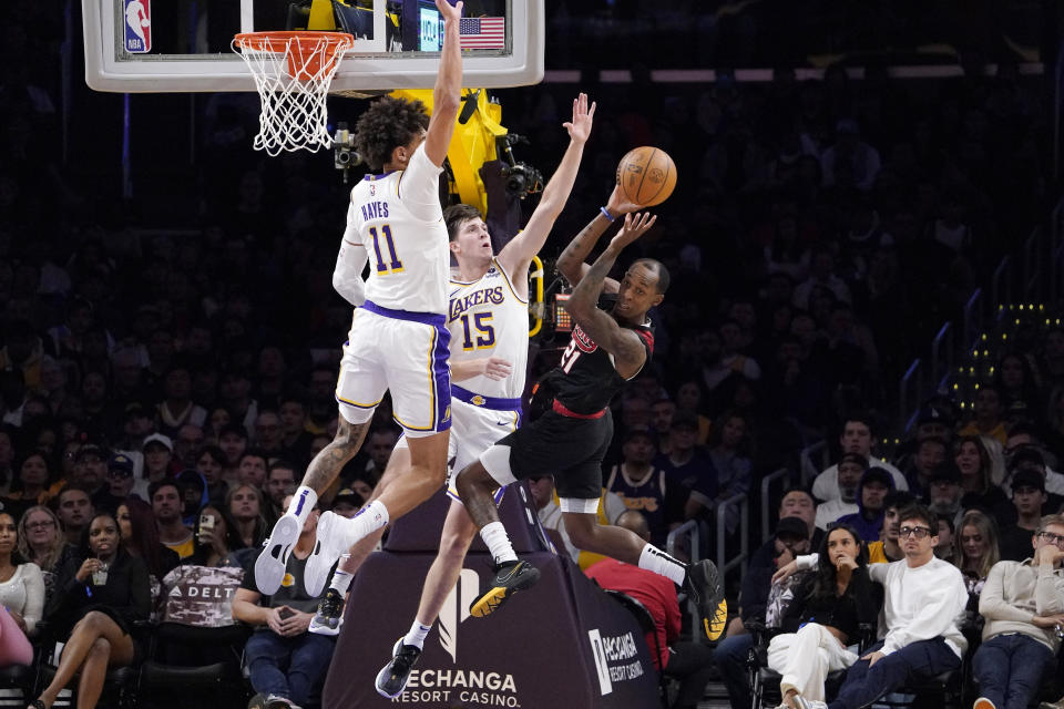 Portland Trail Blazers guard Jamaree Bouyea, right, passes the ball while under pressure from Los Angeles Lakers center Jaxson Hayes, left, and guard Austin Reaves during the first half of an NBA basketball game Sunday, Nov. 12, 2023, in Los Angeles. (AP Photo/Mark J. Terrill)