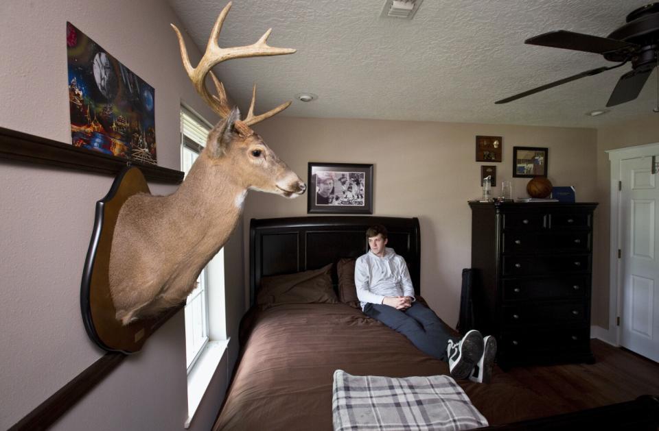 Austin Reaves sits in a chair at his family home.