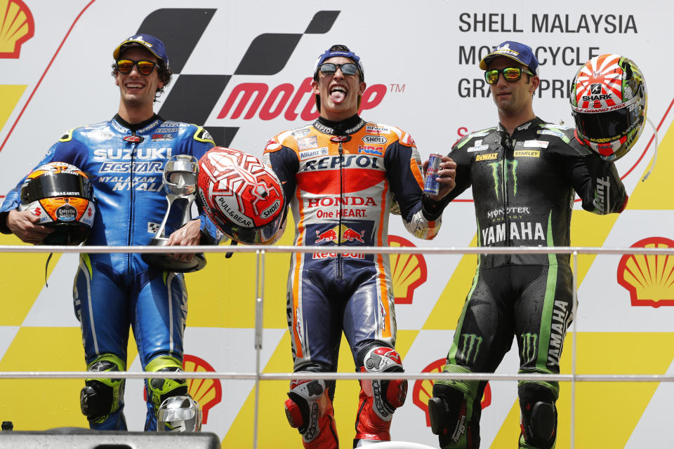 Honda rider Marc Marquez of Spain, center, celebrates with Yamaha rider Johann Zarco of France, right, and Suzuki rider Alex Rins of Spain after winning the Malaysia MotoGP at the Sepang International Circuit in Sepang, Malaysia, Sunday, Nov. 4, 2018. (AP Photo/Vincent Thian)