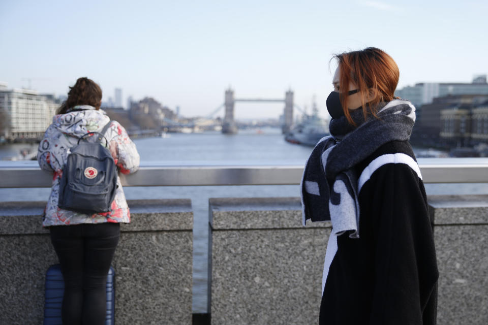 LONDON, ENGLAND - FEBRUARY 07: A woman wears a mask while crossing London Bridge on February 7, 2020 in London, England. A British national, who reportedly contracted coronavirus while in Singapore, became the third person in the UK to test positive for the virus. The person was diagnosed in Brighton and later transferred to an infectious diseases unit at St Thomas' Hospital in London. (Photo by Hollie Adams/Getty Images)