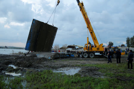 Members of the Iraqi Civil Defence rescue team lift a ferry which sank in the Tigris River with a crane in Mosul, Iraq March, 23, 2019. REUTERS/Stringer