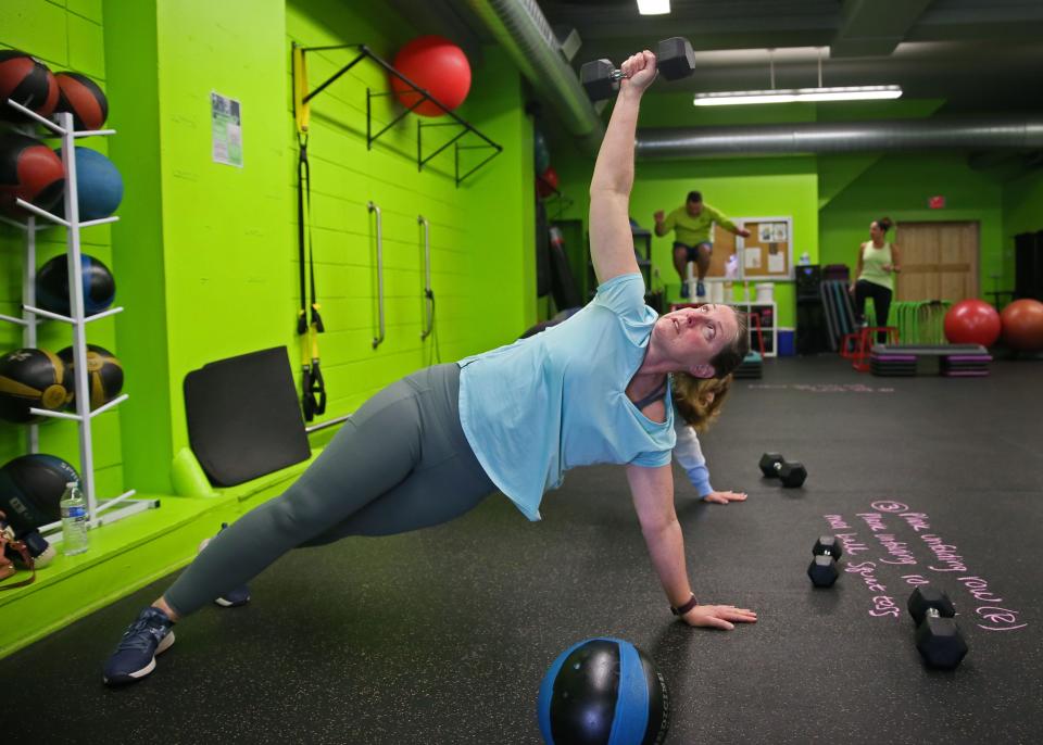 Katrina Kazik performs a side plank unfolding row at Wild gym on Thursday, April 7, 2022 at 2898 South Delaware Ave. in Bay View.