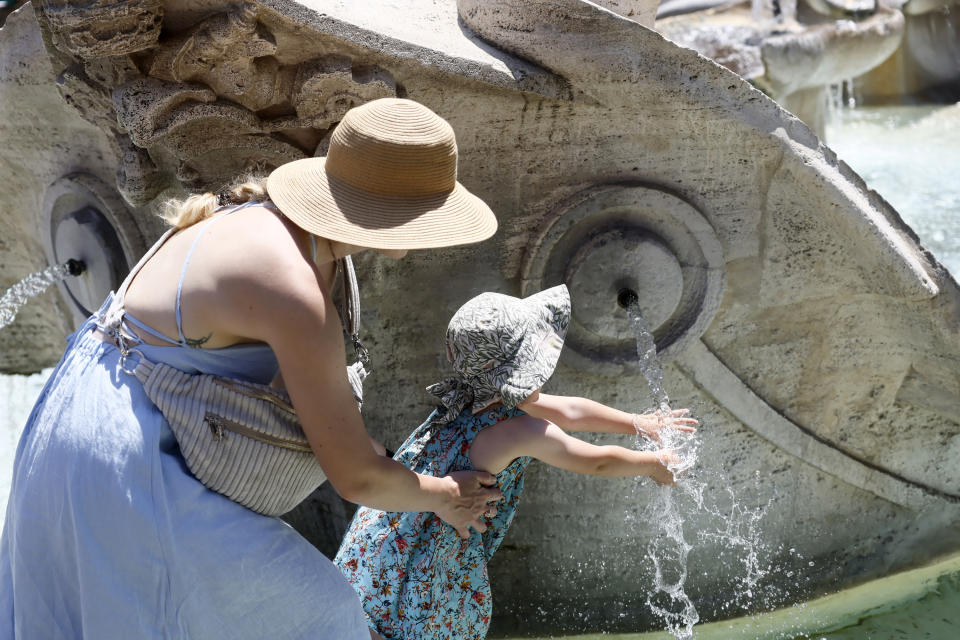 A child cools her hands in the Barcaccia fountain near the Spanish Steps in downtown Rome, Thursday, July 11, 2024. (Cecilia Fabiano/LaPresse via AP)