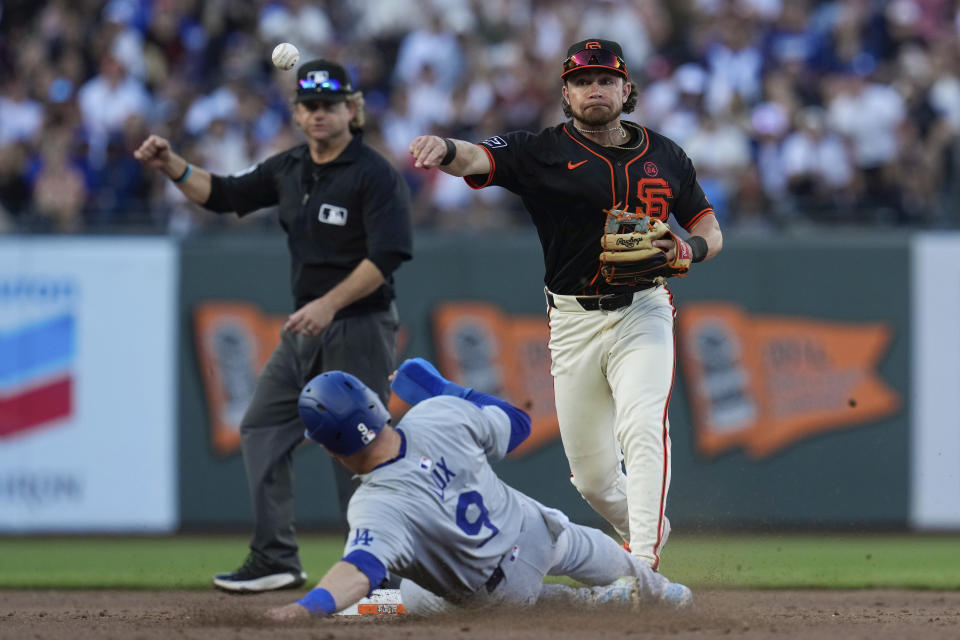 San Francisco Giants second baseman Brett Wisely, right, turns a double play after forcing out Los Angeles Dodgers' Gavin Lux at second during the eighth inning of a baseball game Saturday, June 29, 2024, in San Francisco. Kiké Hernández was out at first. (AP Photo/Godofredo A. Vásquez)