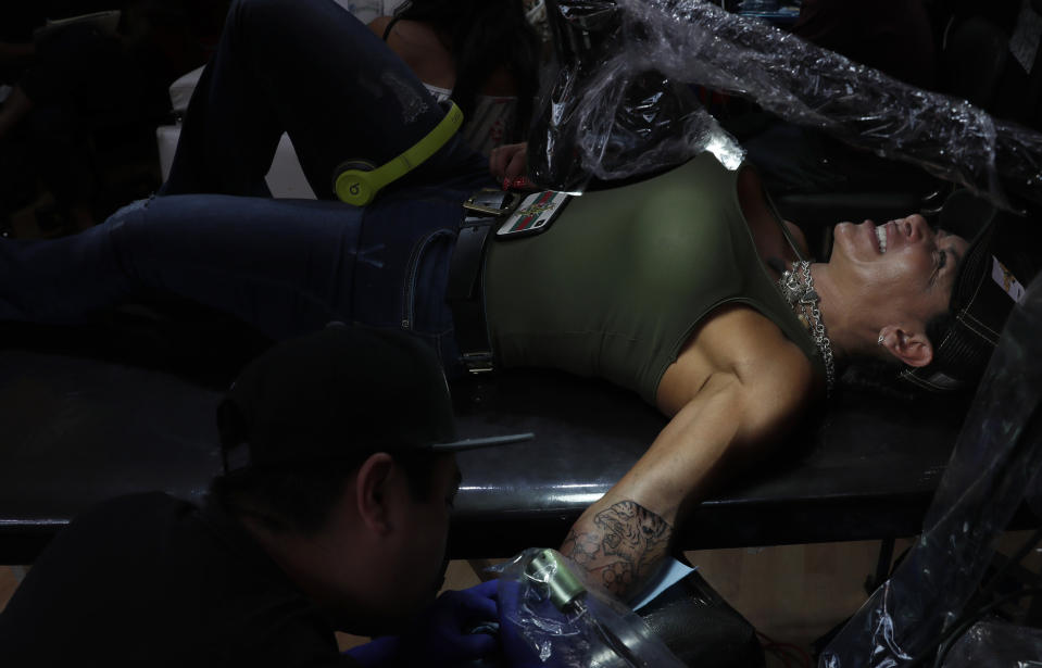 In this April 15, 2019 photo, Liz Ruiz has the tattoo of a tiger inked on her arm at the Corona Tattoo parlor in Mexico City. "Every animal has a meaning but when you find the most beautiful animal in the world, his beauty, strength, royalty and freedom, you will understand the significance behind the tiger tattoo." Ruiz said. (AP Photo/Marco Ugarte)