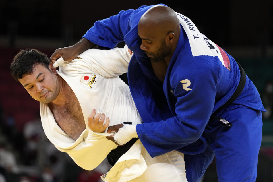 Aaron Wolf of Japan, left, and Teddy Riner of France compete during their gold medal match in team judo competition at the 2020 Summer Olympics, Saturday, July 31, 2021, in Tokyo, Japan. (AP Photo/Vincent Thian)