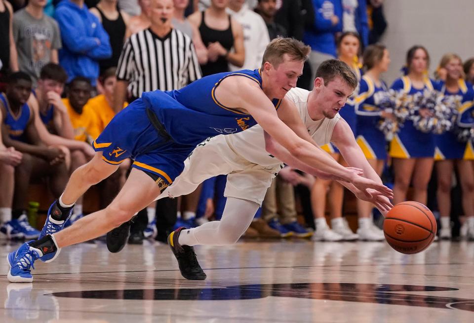 Homestead Spartans Fletcher Loyer (2) and Westfield Shamrocks Braden Smith (1) leap for the ball on Saturday, March. 12, 2022, at Homestead High School in Logansport. Westfield Shamrocks defeated the Homestead Spartans, 64-53.