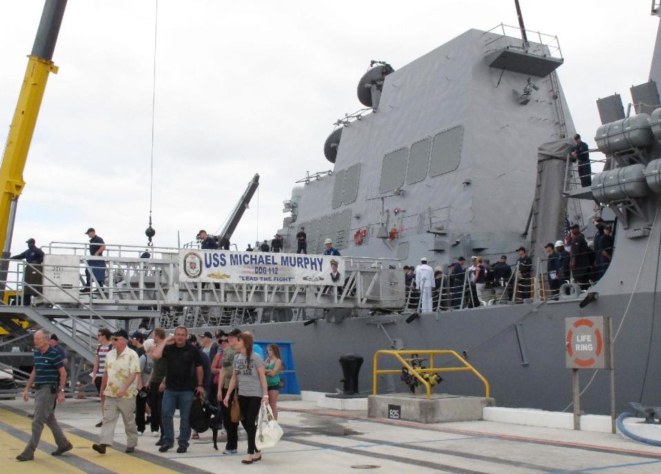 Passengers from a disabled Canadian naval ship walk off the American naval destroyer USS Michael Murphy after being escorted to Pearl Harbor, Hawaii, Tuesday, March 4, 2014. A U.S. Navy ocean tug was towing the Canadian ship after an engine fire left 20 sailors with minor injuries. (AP Photo/Oskar Garcia)