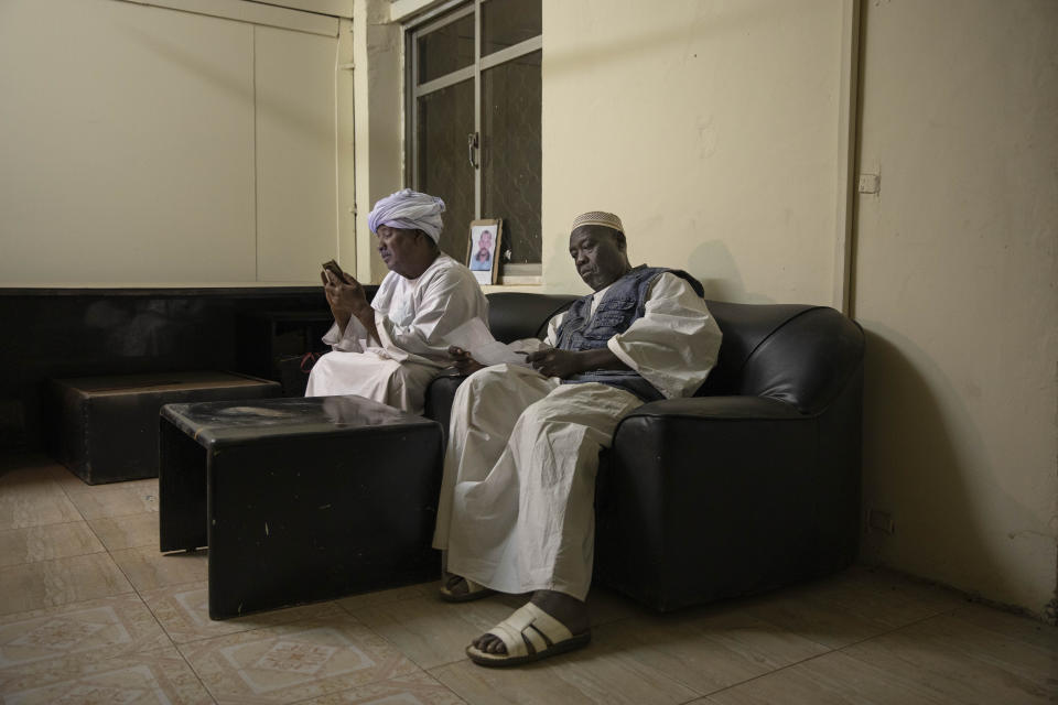 In this Jan. 11, 2020 photo, Sudanese fathers who lost their sons during last years' revolution, Farrah Abbas Farrah, left, and Abu Bakr, look at their son's photos and read documents, after a meeting for families who lost loved ones, at the Revolutionary Martyrs Center, in Khartoum, Sudan. Nearly a year after the ouster of former President Omar al-Bashir, the country faces a dire economic crisis, leaving many young people jobless. Generals remain the de-facto rulers of the country and have shown little willingness to hand over power to a civilian-led administration, one the demonstrators' key demands. (AP Photo/Nariman El-Mofty)