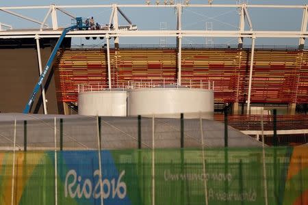 Workers are pictured in the tennis venue at the 2016 Rio Olympics Park in Rio de Janeiro, Brazil, July 11, 2016. REUTERS/Bruno Kelly