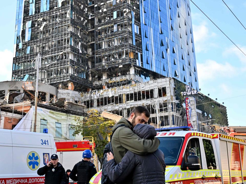 People react outside a partially destroyed multistorey office building after several Russian strikes hit the Ukrainian capital of Kyiv (AFP via Getty Images)