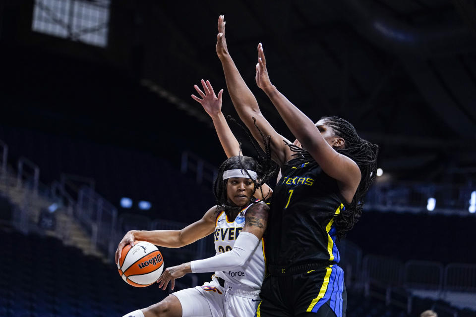 Indiana Fever guard Destanni Henderson (33) drives under Dallas Wings center Teaira McCowan (7) in the first half of a WNBA basketball game in Indianapolis, Sunday, July 24, 2022. (AP Photo/Michael Conroy)