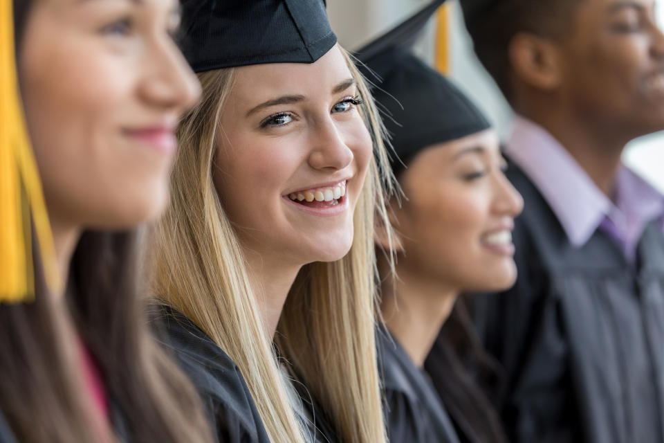 Graduates in caps and gowns smiling during a commencement ceremony