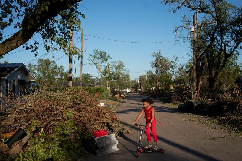 Iyana Sells, 9, plays on her street which is still lined with debris from Hurricane Laura the day after Hurricane Delta swept through Lake Charles