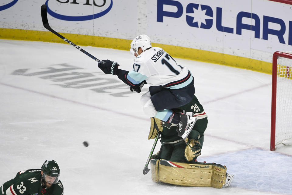 Seattle Kraken left wing Jaden Schwartz, top, draws a penalty for goalie interference after colliding with Minnesota Wild goalie Marc-Andre Fleury (29) during the first period of an NHL hockey game Monday, March 27, 2023, in St. Paul, Minn. (AP Photo/Craig Lassig)