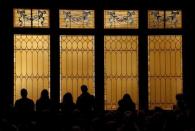 People stand against windows during a vigil held at All Souls Unitarian Universalist Church the day after a gunman opened fire on a Planned Parenthood clinic in Colorado Springs, Colorado November 28, 2015. REUTERS/Isaiah J. Downing