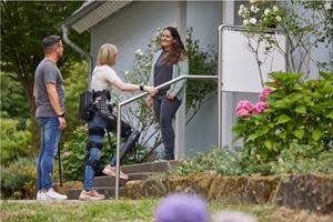 A paralyzed individual walks up the stairs to visit a friend's home using her ReWalk Personal Exoskeleton.