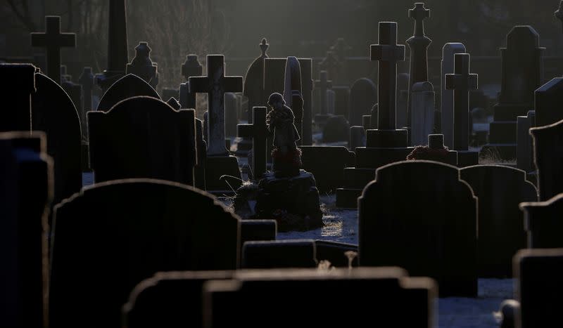 Sunlight hits frost covered headstones in a graveyard amid COVID-19 outbreak in Manchester